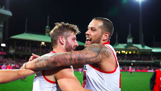 Franklin and Johnson celebrate after the Swans beat the Pies
